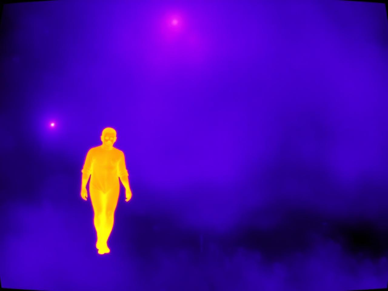 Thermal imaging output showing a warm human silhouette in a foggy scene